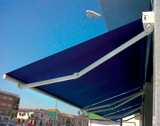 Toldo de color azul con estructura metálica, montado en un edificio bajo un cielo despejado.